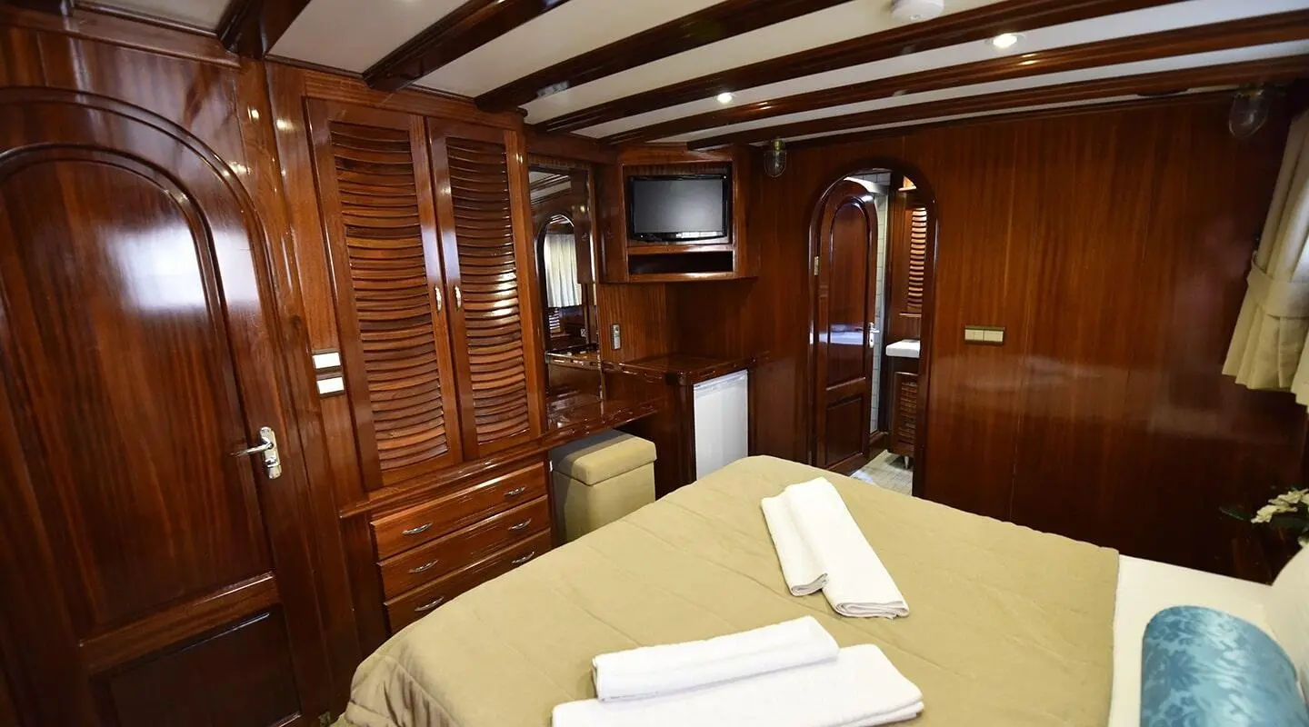 Kayhan Kaptan luxury yacht cabin interior with polished wood paneling and built-in storage