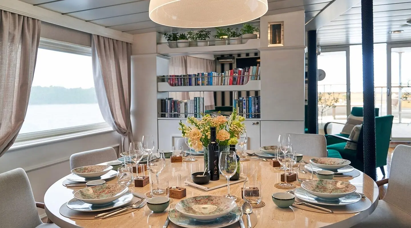 La Perla yacht dining table setup with flowers and wine on a round table