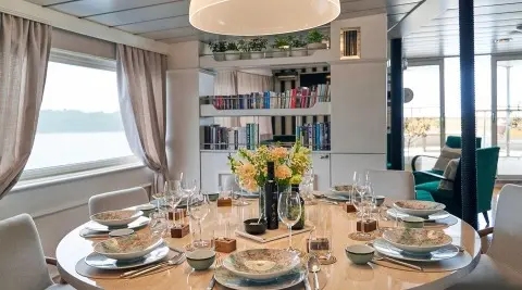 La Perla yacht dining table setup with flowers and wine on a round table