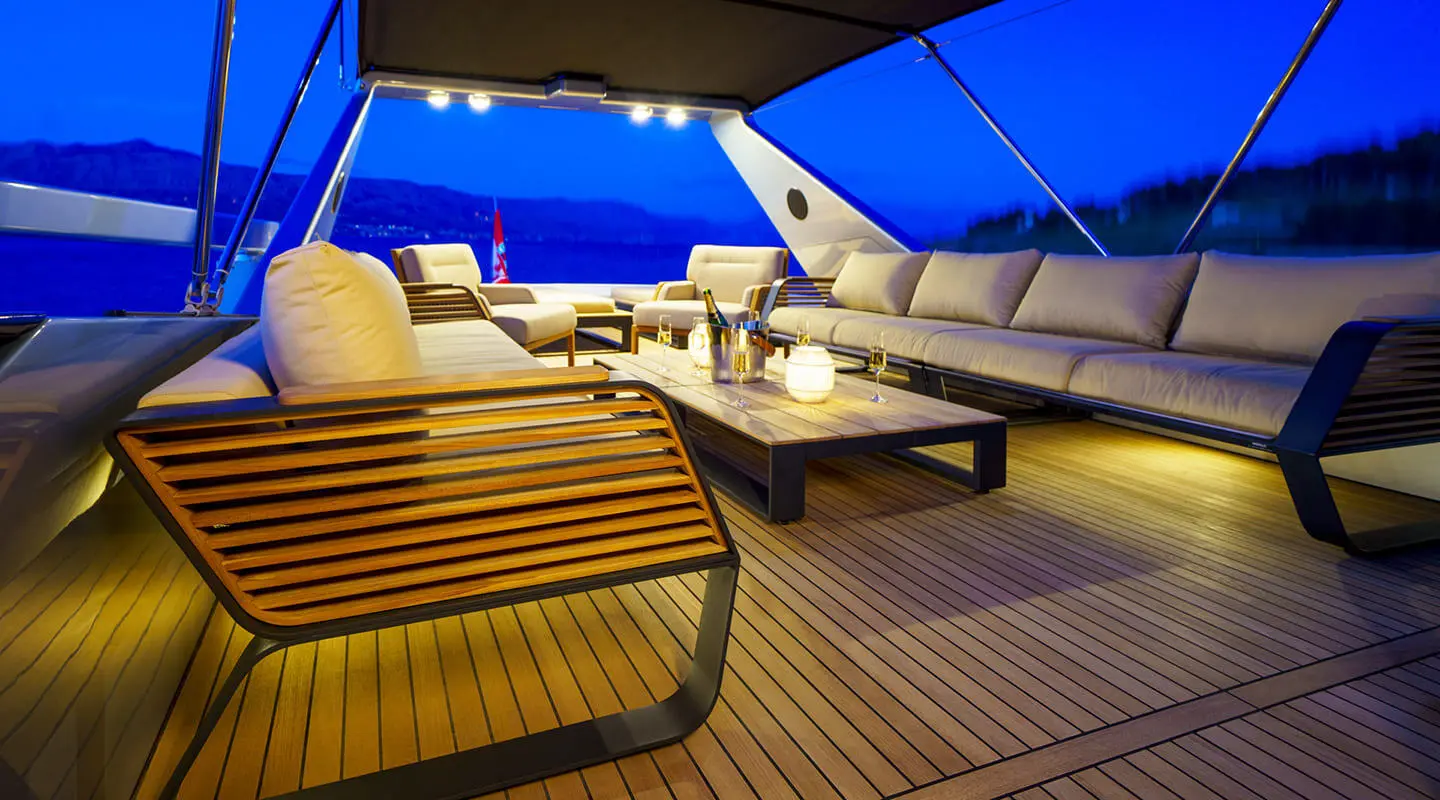 Phantom motor yacht on deck at night with sun loungers and seating area illuminated