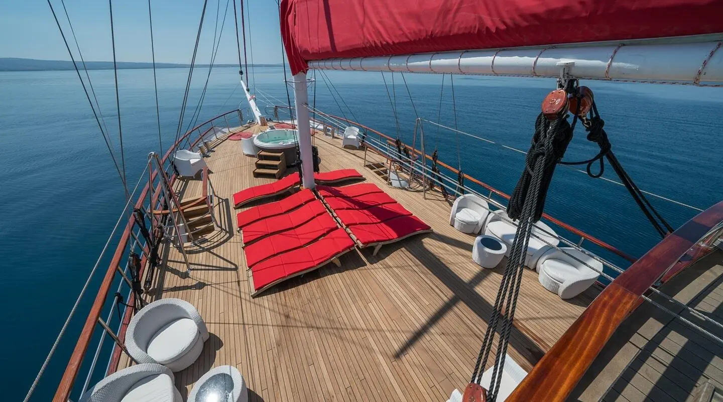 View of a luxury yacht deck with red lounge cushions and sunbathing area