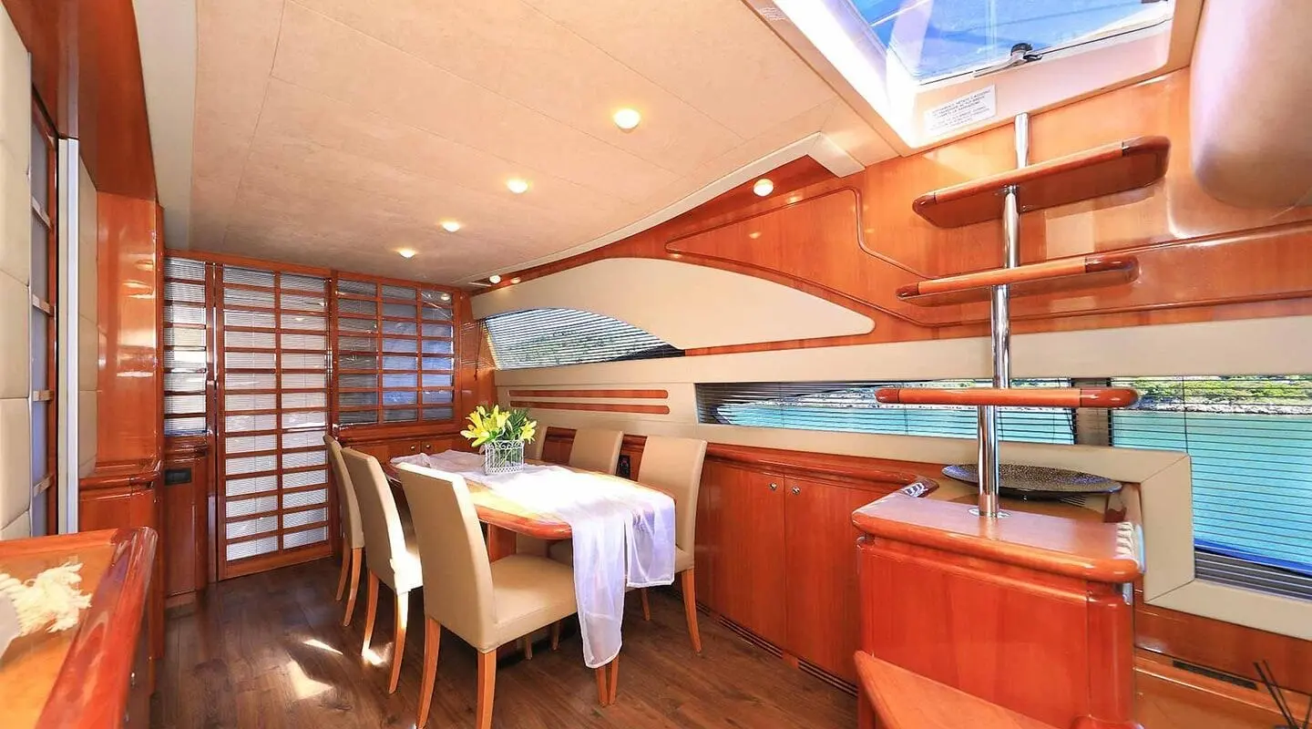 Elegant dining area aboard the yacht Quo Vadis I with wooden interior and table setup