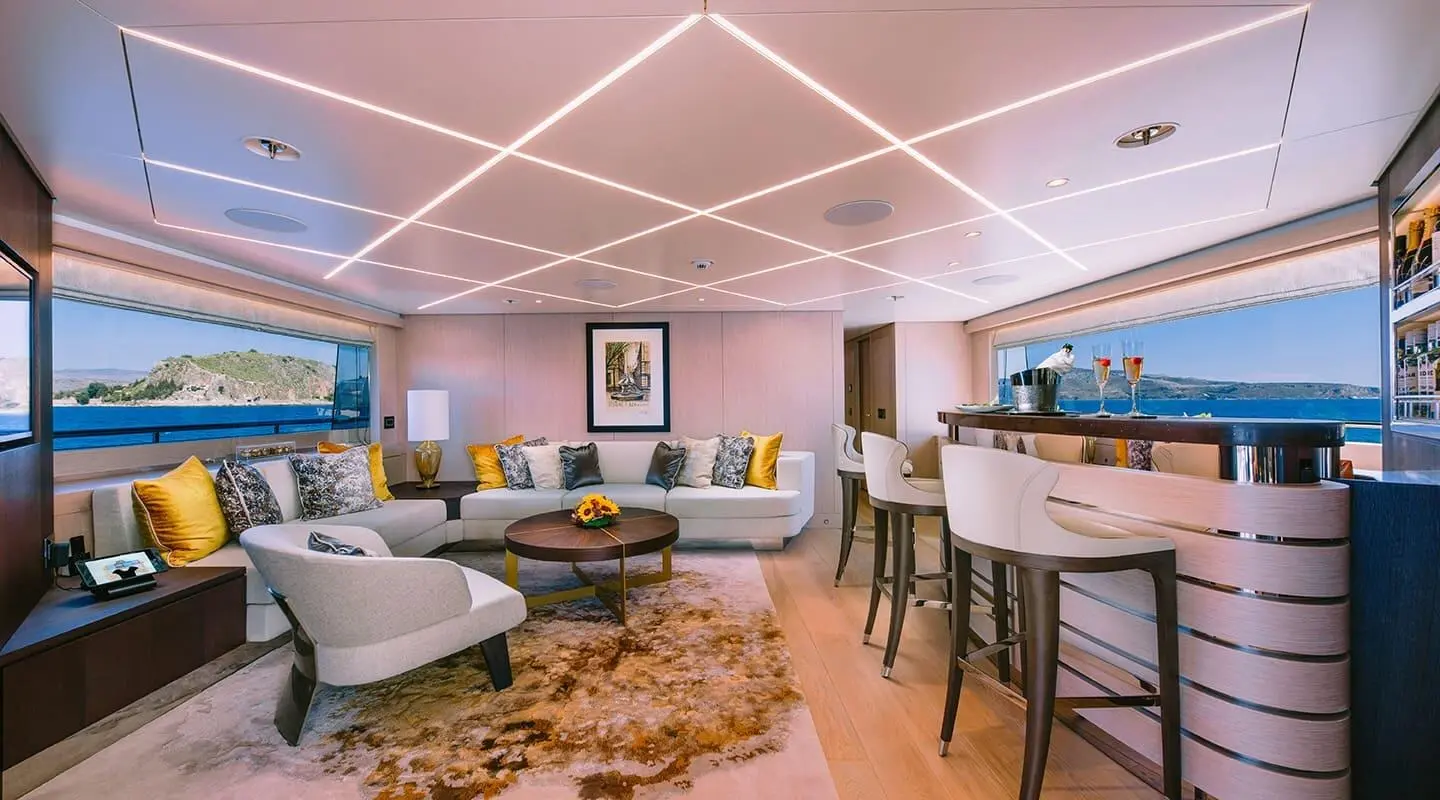 Interior of Xana yacht lounge with seating, coffee tables, and geometric ceiling lighting