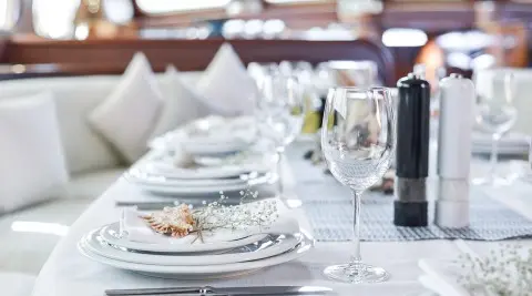 Lady Christa yacht at sunset with dining table set on deck and white napkins