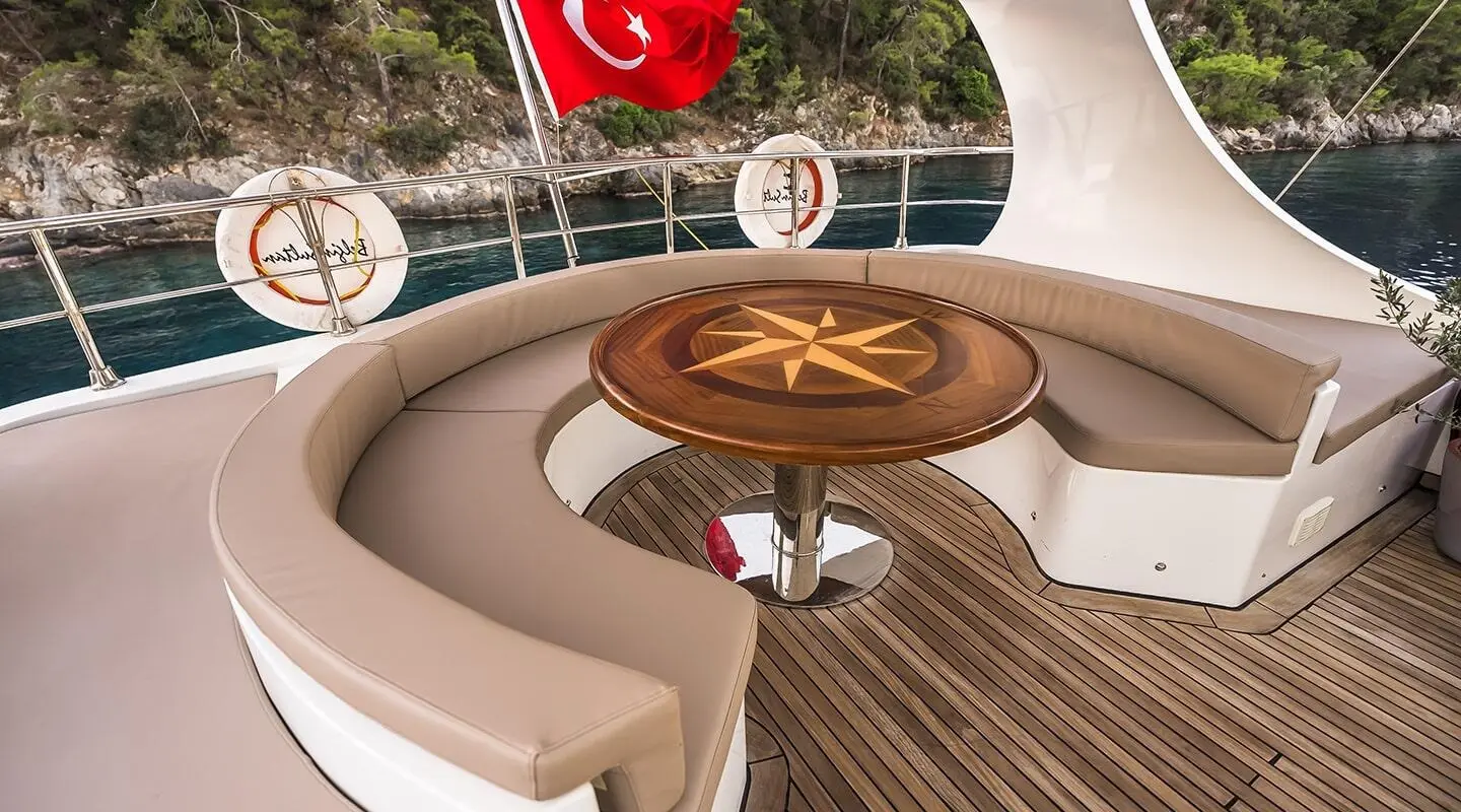 Yacht Belgin Sultan showing a curved seating area on deck with a round wooden table