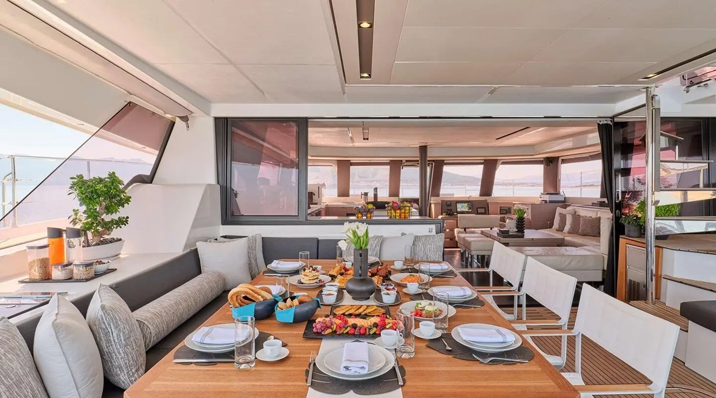 Christal Mio yacht interior with dining table set for dinner on sunny deck