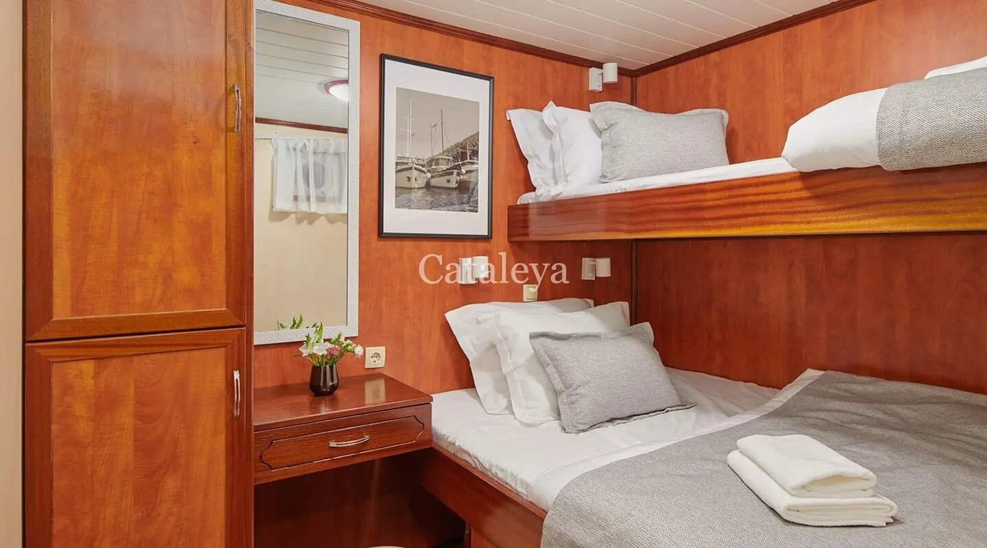 Gulet Cataleya cabin with double bed and bunk bed in warm wooden interior