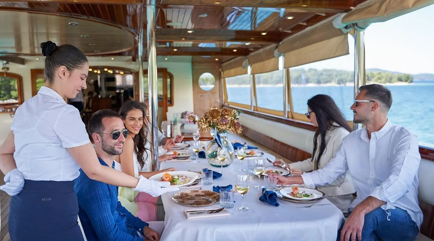 Casablanca yacht dining al fresco on deck with guests enjoying gourmet meal onboard