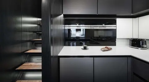 Sleek yacht galley with dark cabinets and bright countertop lighting