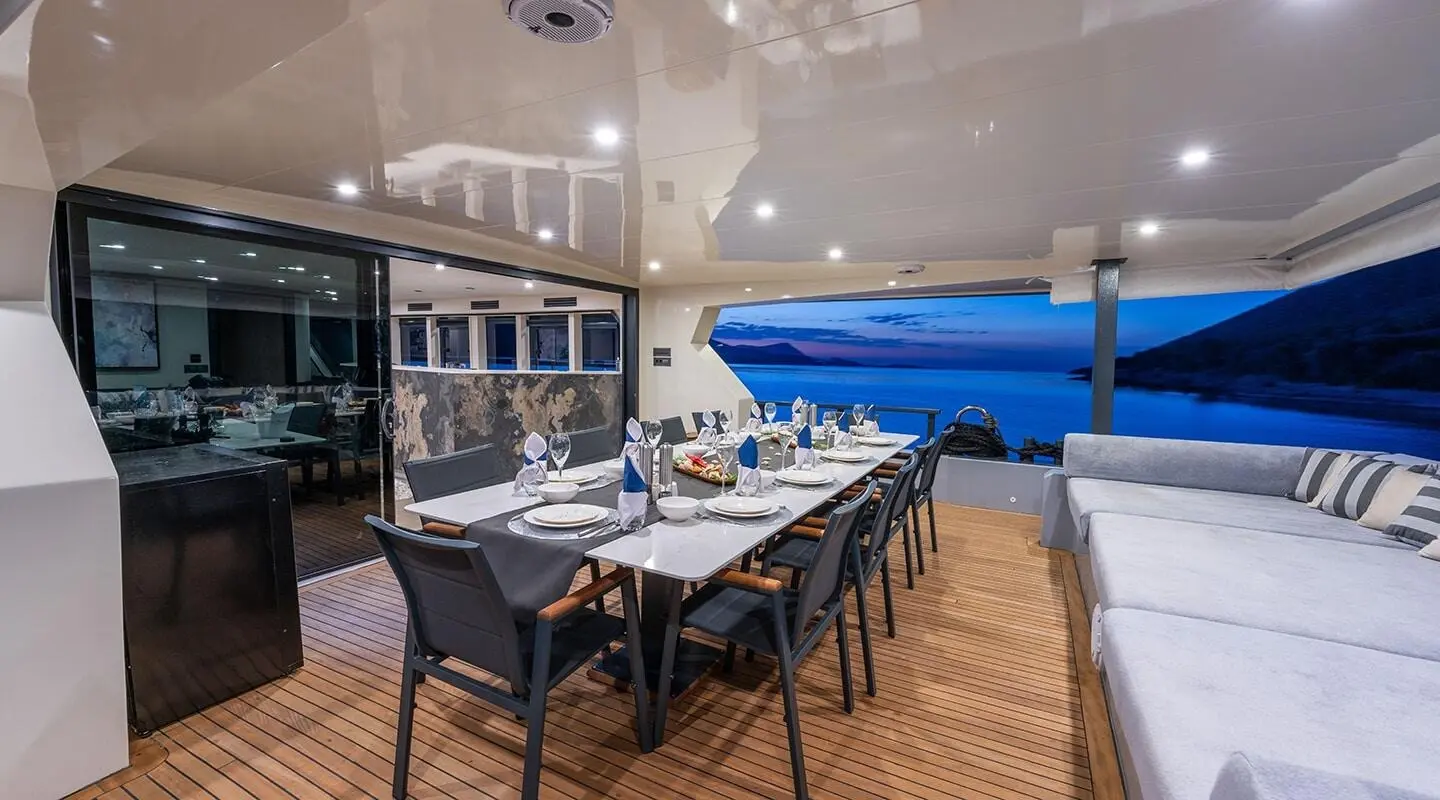 Calm Down yacht dining area on deck at sunset with table set for guests