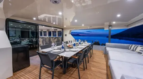 Calm Down yacht dining area on deck at sunset with table set for guests