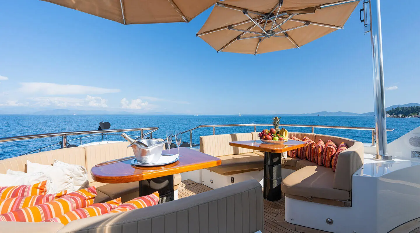 Serenity yacht lounge area with wicker seating, parasols, and ocean view
