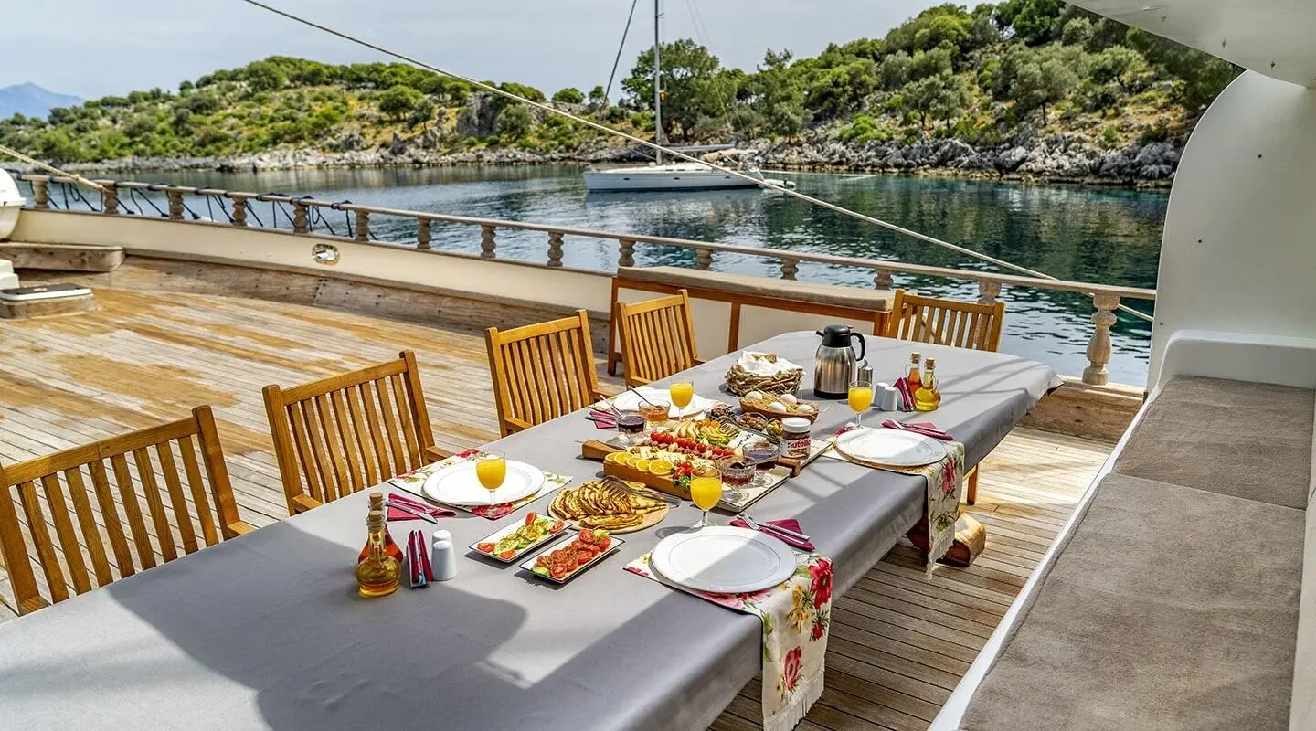 Bow deck dining setup on Tersane 8 gulet with table linen and plates