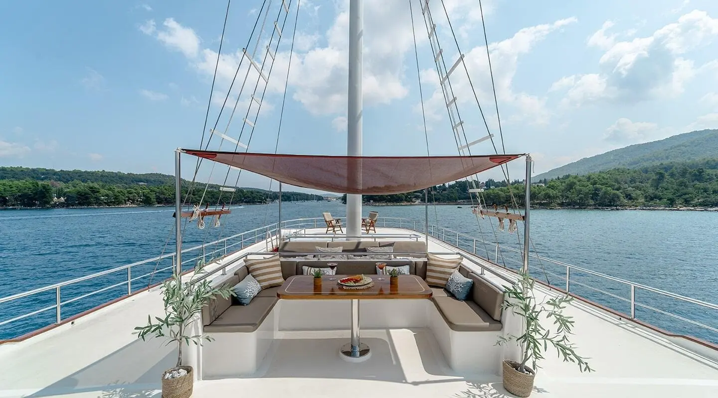 Sun deck of Cesarica gulet with seating, shade sun awning, calm blue sea