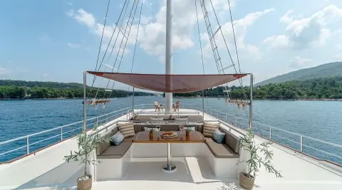 Sun deck of Cesarica gulet with seating, shade sun awning, calm blue sea
