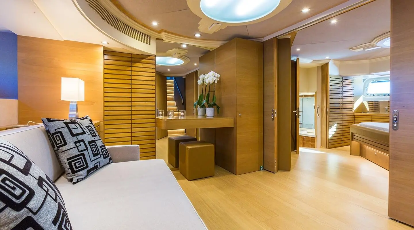 Aquarella master cabin lounge with sofa bed and warm wood panels