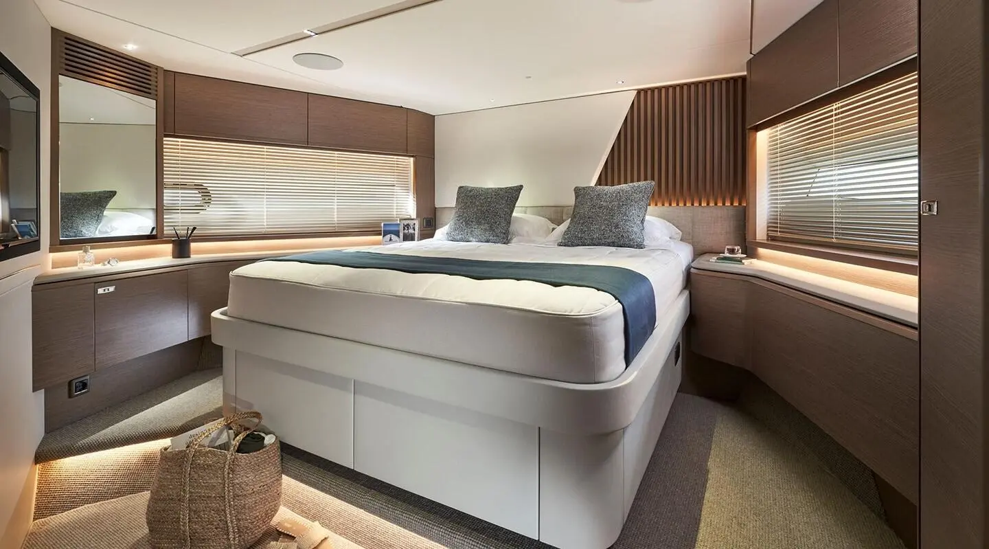 Elizabeth yacht bedroom with a large bed, plush pillows, and warm lighting