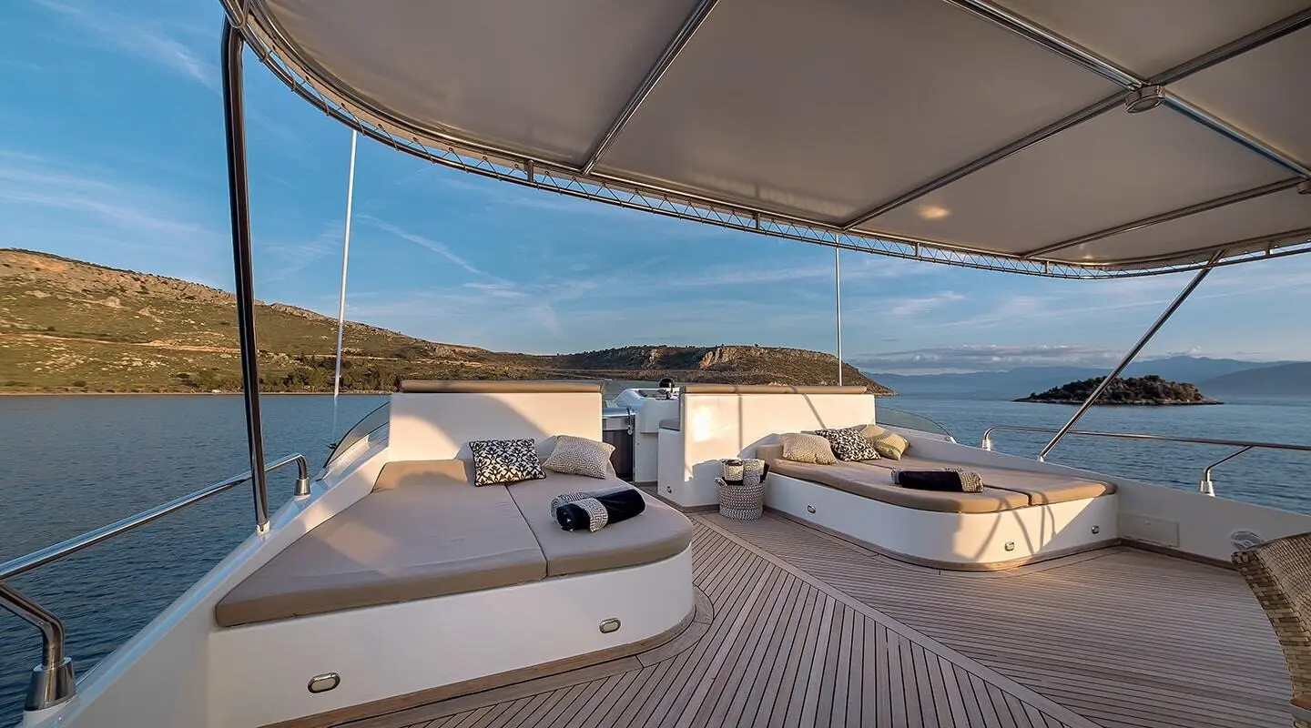 Aquila luxury yacht deck at sunset with seating, rope railing and calm water