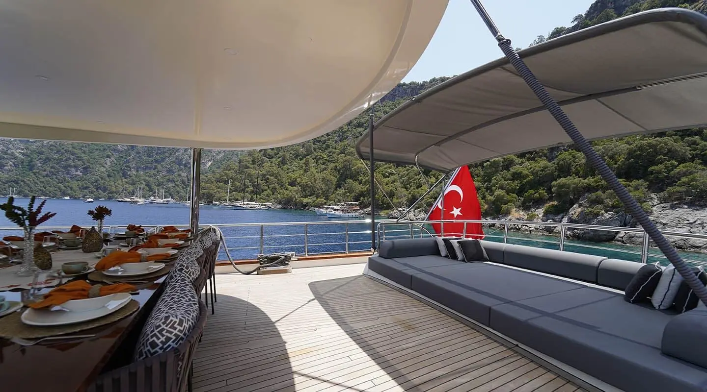 Queen Of Makri yacht deck at sunset with seating and calm blue sea