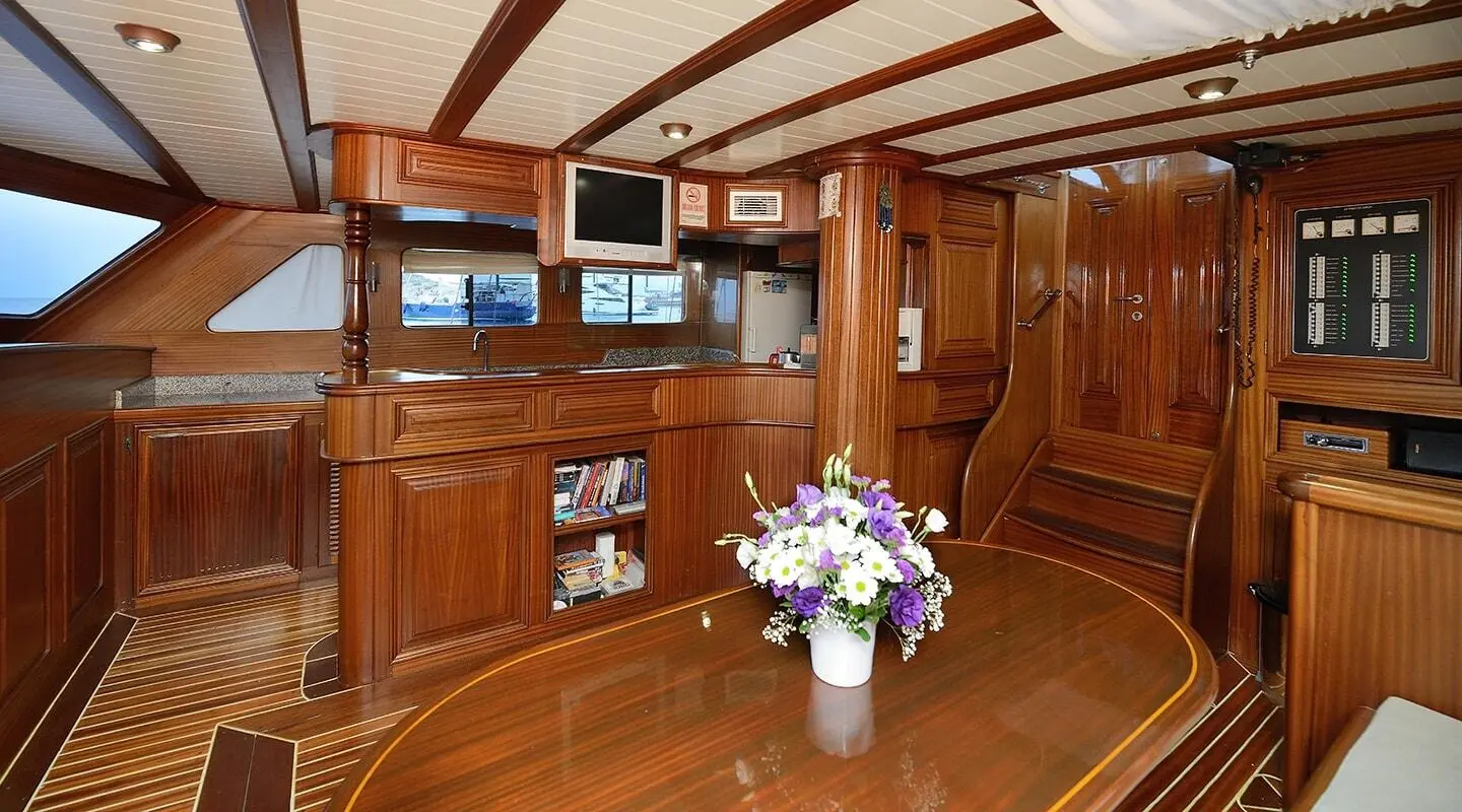 Inside the samarkand yacht with polished wood interiors and a vase of flowers