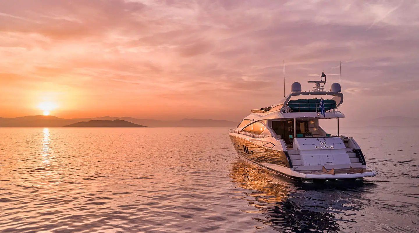 Yacht M Five anchored at sunset with calm water and warm sky