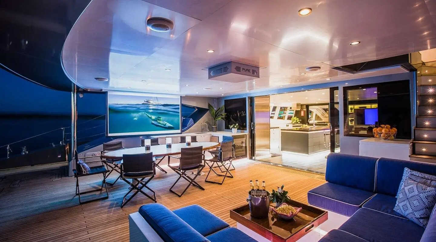 Interiors of Cartouche yacht with blue seating, lounge area, and warm lighting