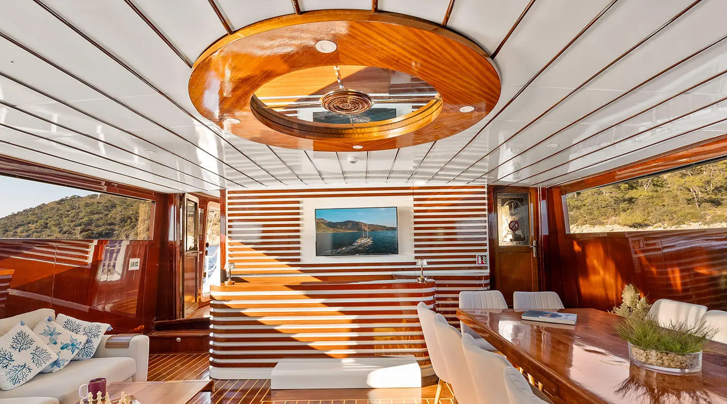 Inside saloon of Esma Sultan gulet, wood paneling, seating, and framed artwork
