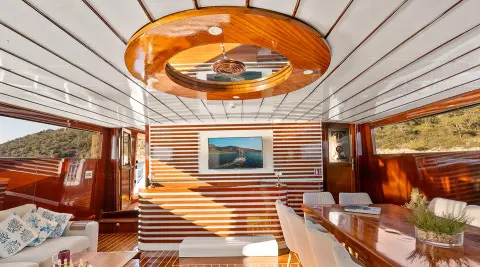 Inside saloon of Esma Sultan gulet, wood paneling, seating, and framed artwork