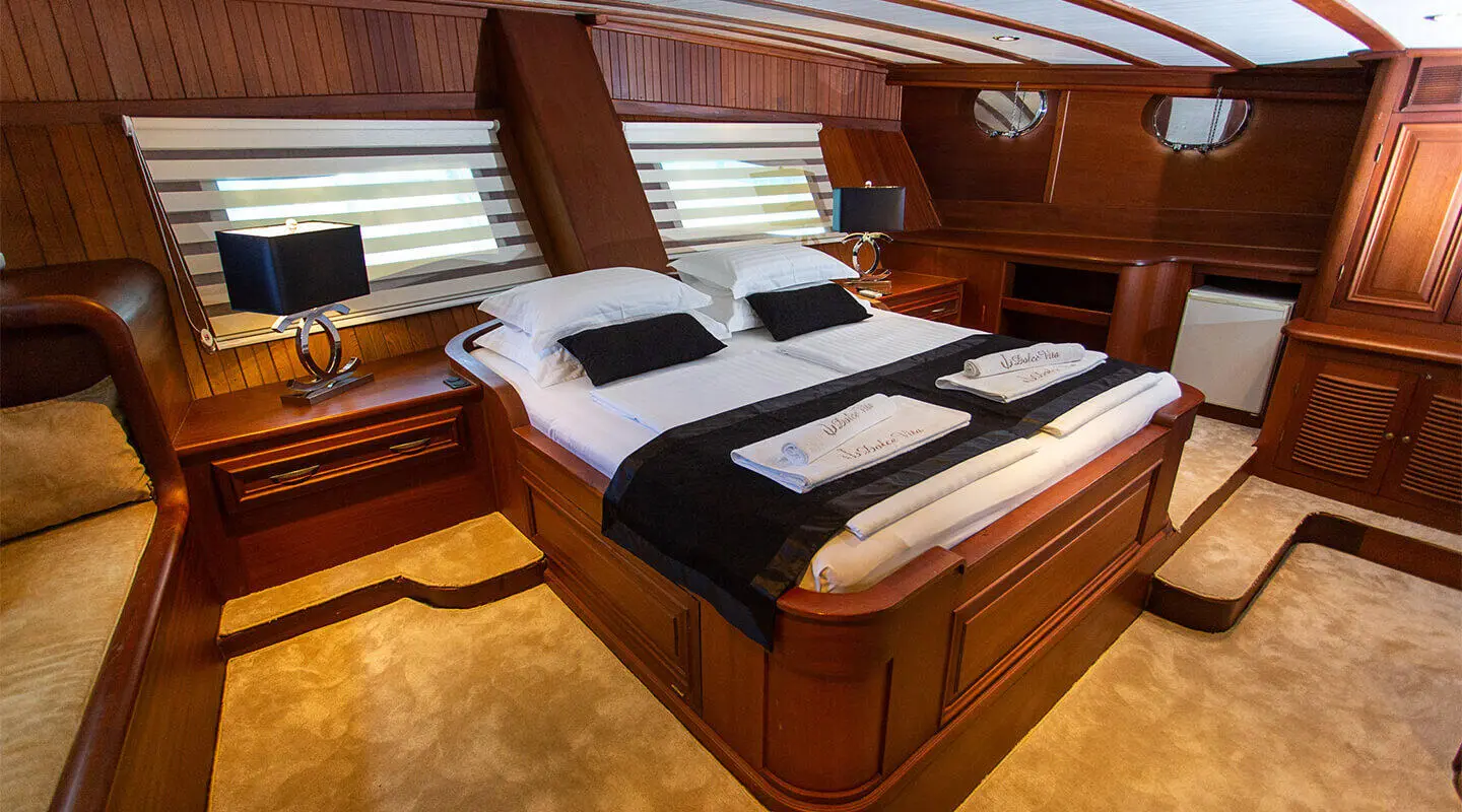 Dolce Vita yacht cabin with two black and white striped beds and wood interior