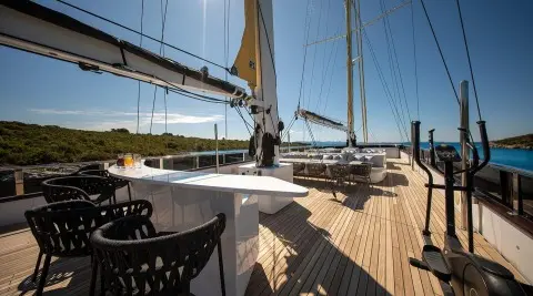 Yacht Anima Maris on sun deck with seating and railing on calm water