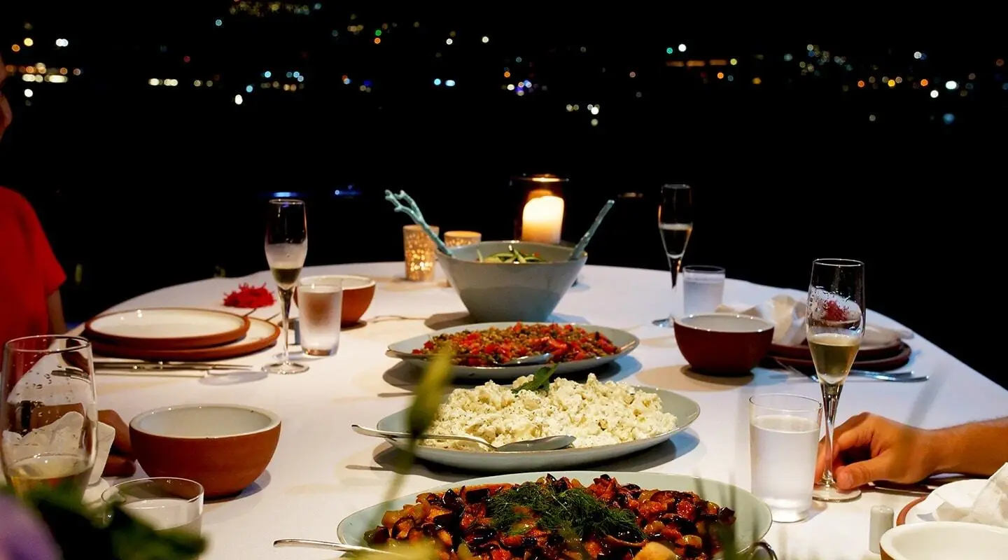 Cobra King yacht dining scene at sunset with plates and glasses on table