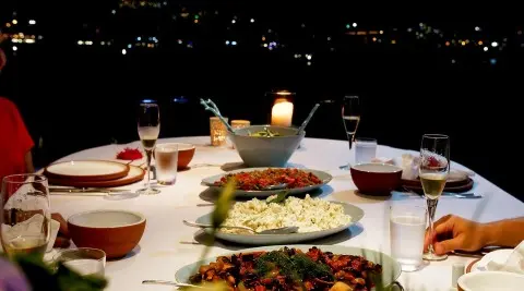 Cobra King yacht dining scene at sunset with plates and glasses on table