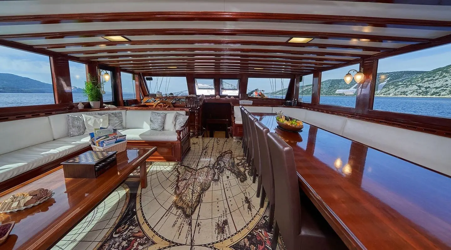 Interior view of a gulet yacht saloon with wooden deck and seating