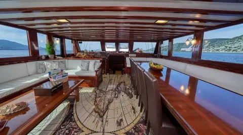 Interior view of a gulet yacht saloon with wooden deck and seating