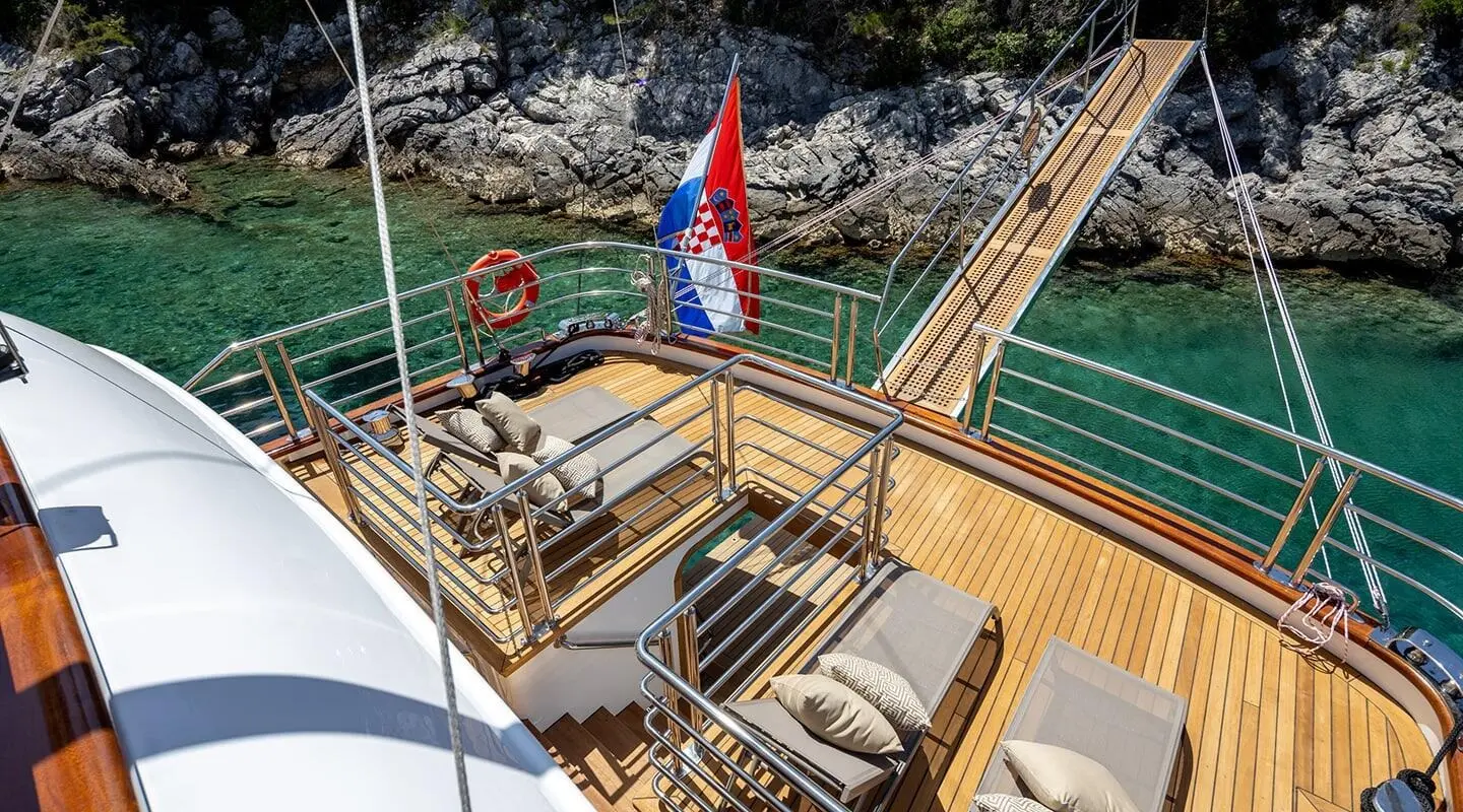 Love Story yacht deck with sun loungers on teak, Croatia coastline backdrop