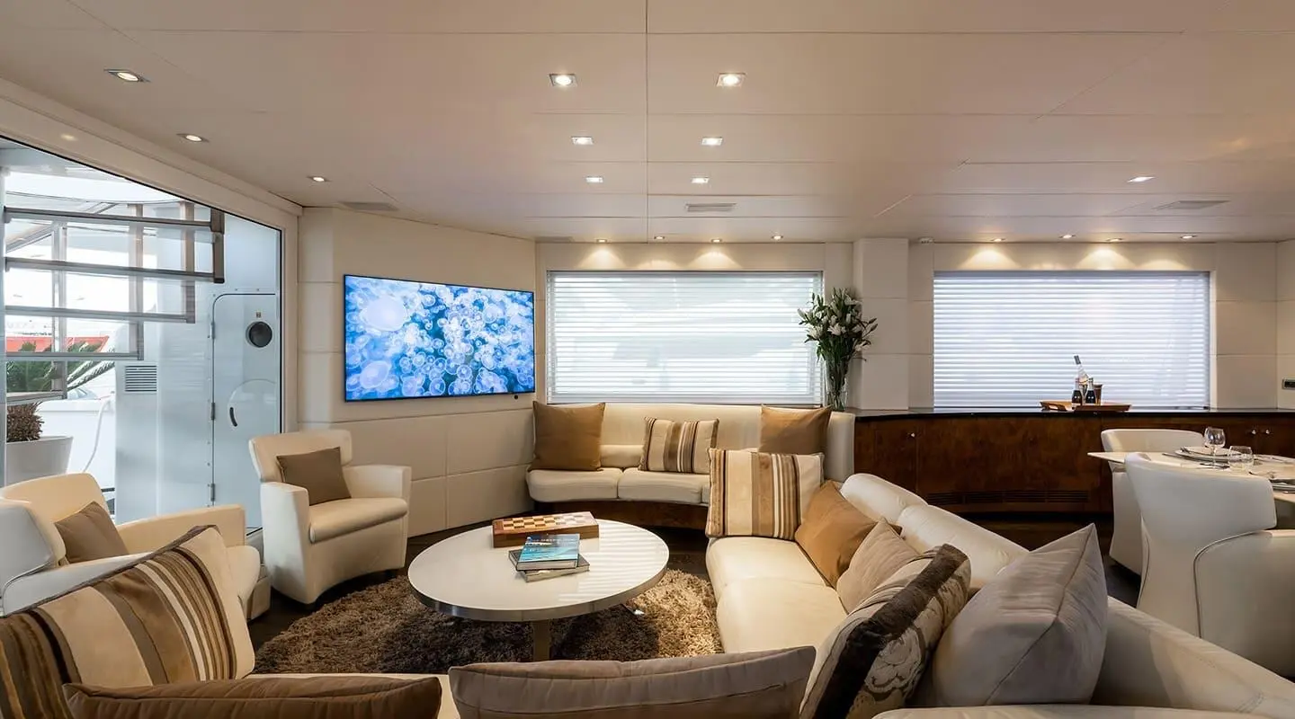 Cozy yacht saloon interior with couches, round coffee table, and padded chairs