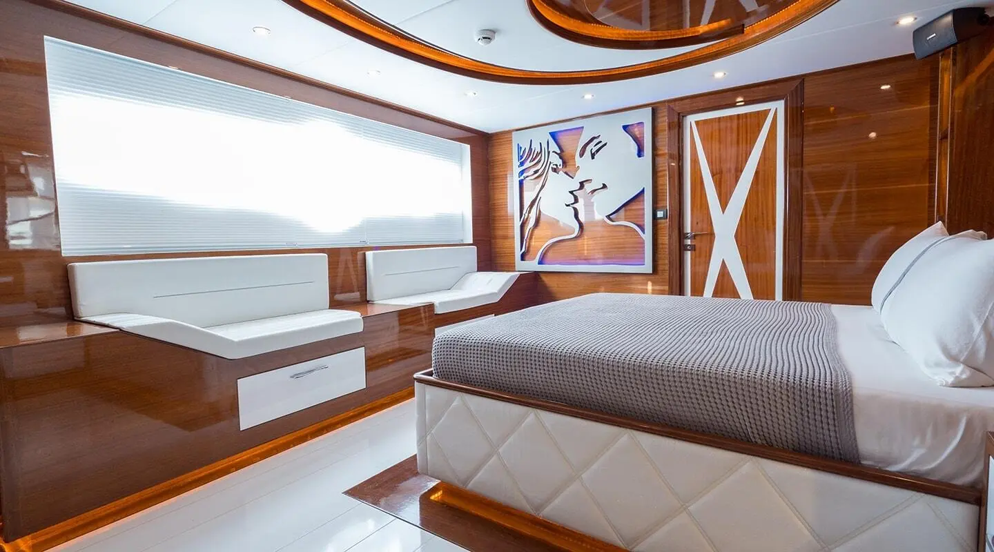 Interior of a gulet yacht with wooden cabinetry, seating, and window view