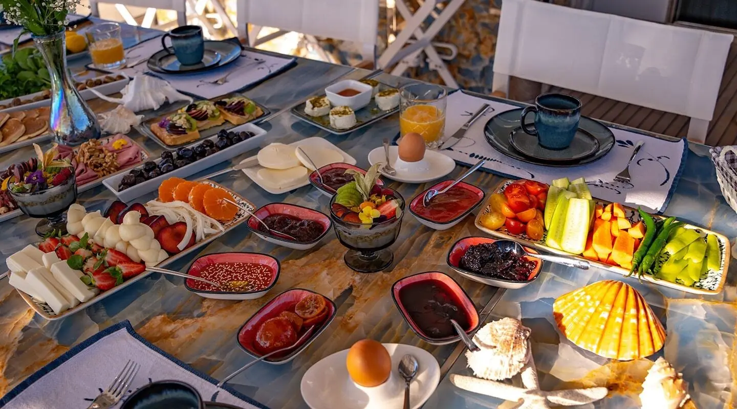 Elegant open deck breakfast spread with colorful tapas and fruit platters
