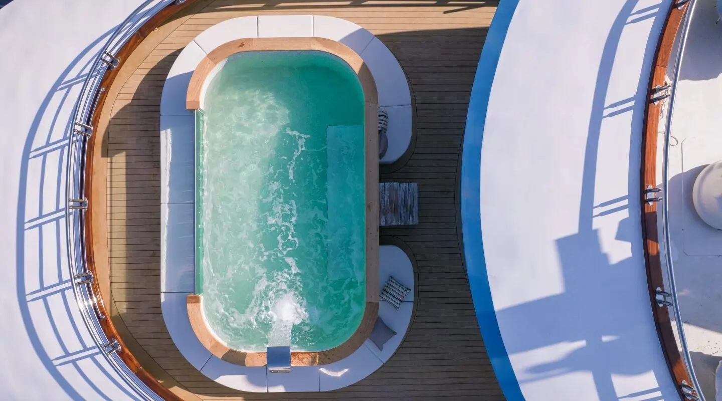 Top-down view of a luxury yacht Freedom with a turquoise pool and wooden deck