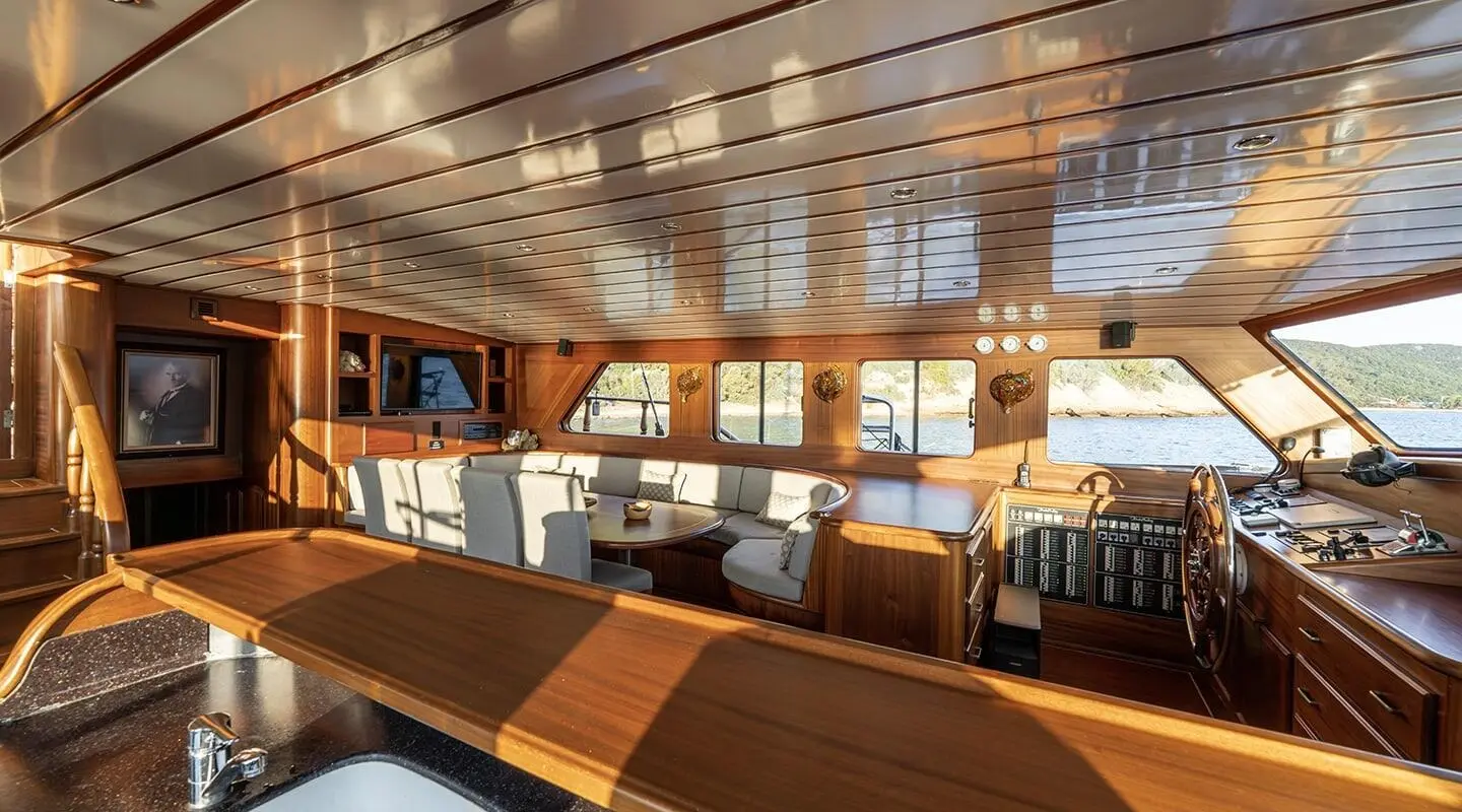Wooden interior of a gulet saloon with seating area and helm station