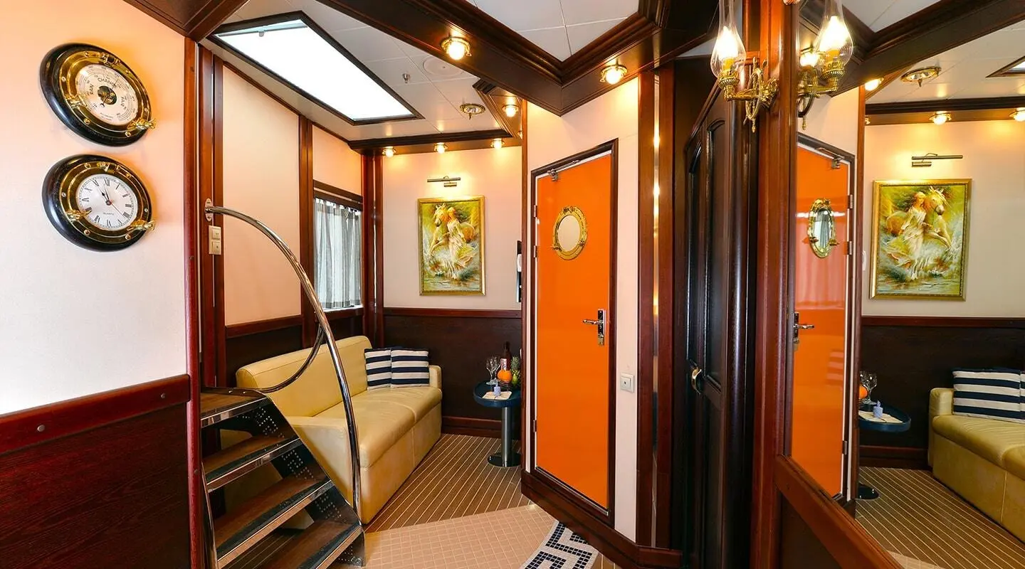 Luxurious yacht interior with warm lighting, staircase, and elegant wood trim