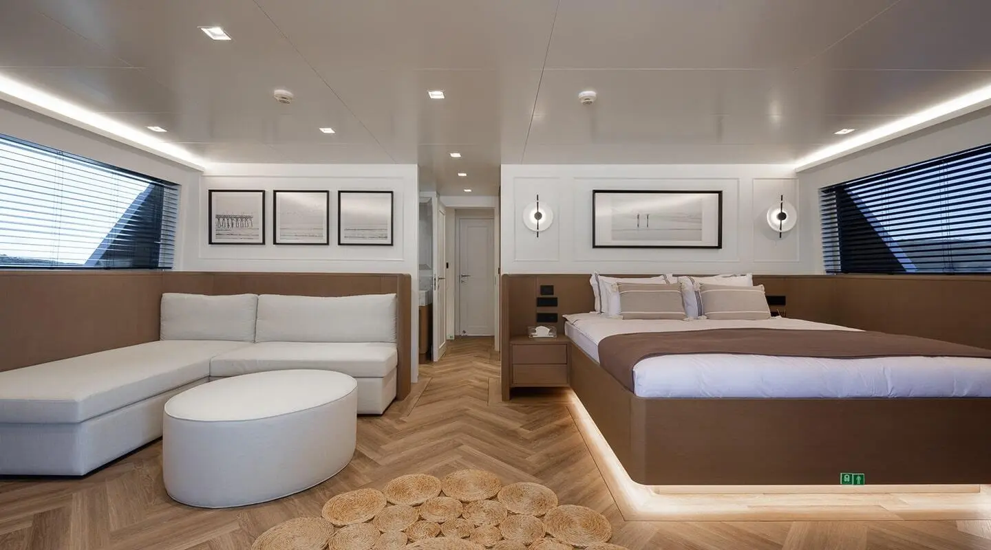 Illusion II yacht interior: modern cabin with bed, seating area, and framed art