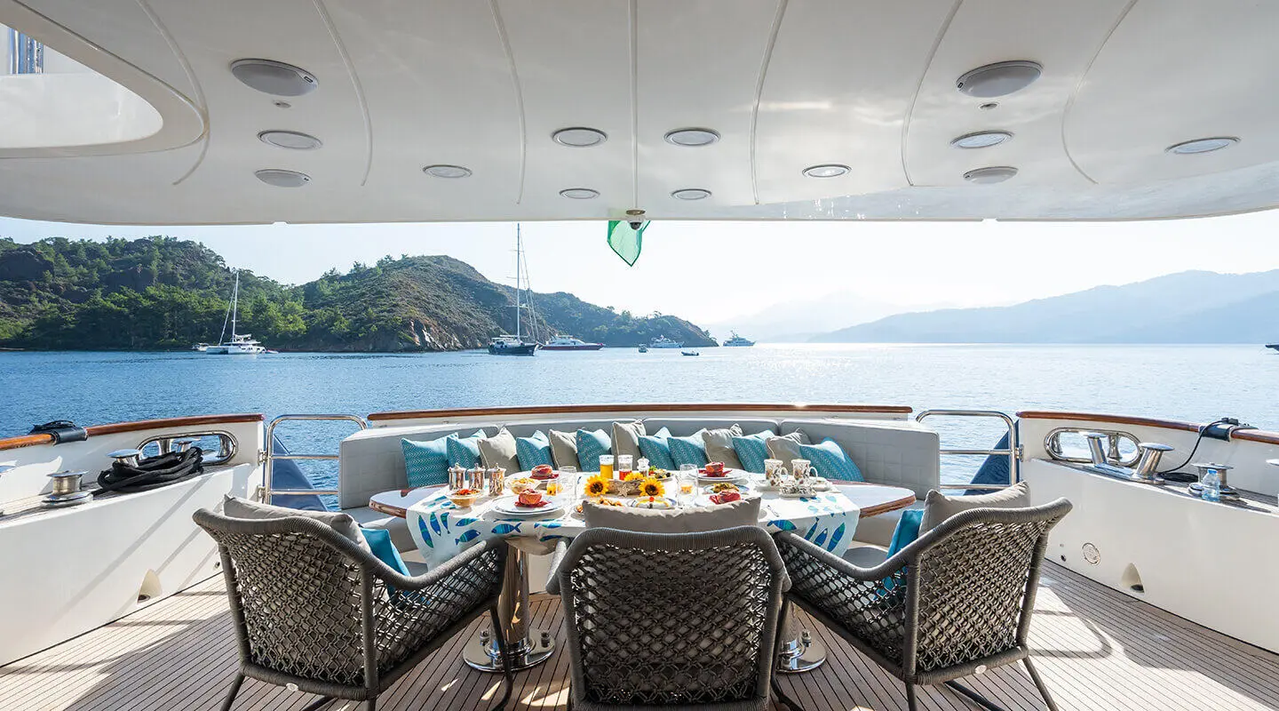 Amadea yacht dining on deck with ocean view and distant coastline