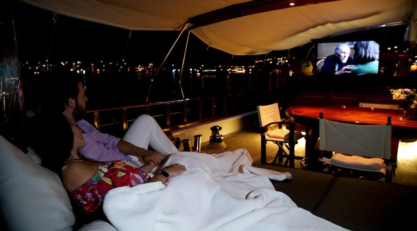 Cobra King yacht at sunset with lounge area and string lights visible