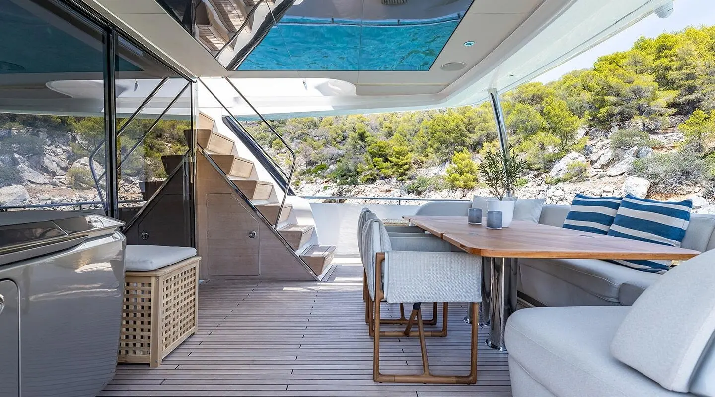 Vista yacht dining area on deck with table, chairs, and poolside view