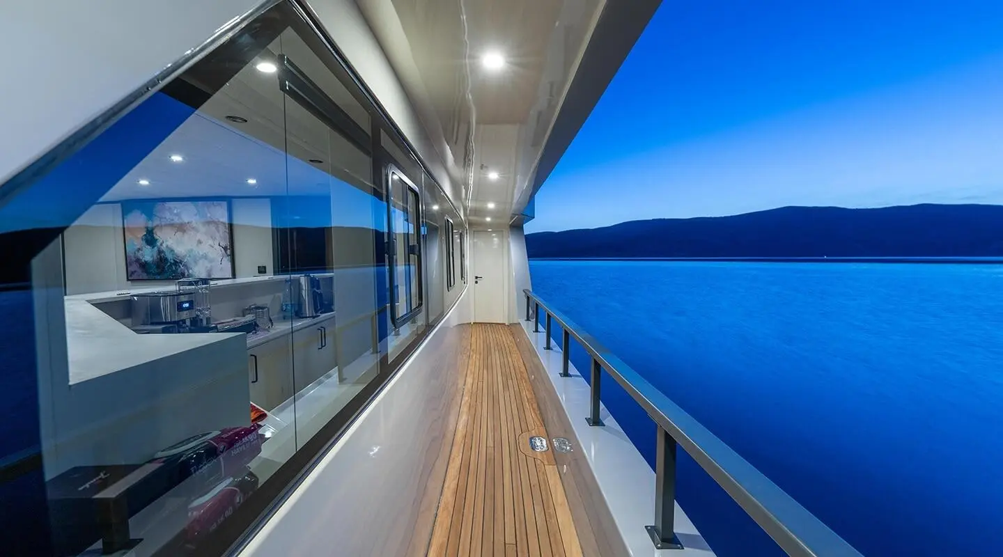 Calm Down yacht deck view with wood planks and blue sea on right