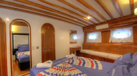 Angelo II master cabin with wood paneling, bed, and porthole windows