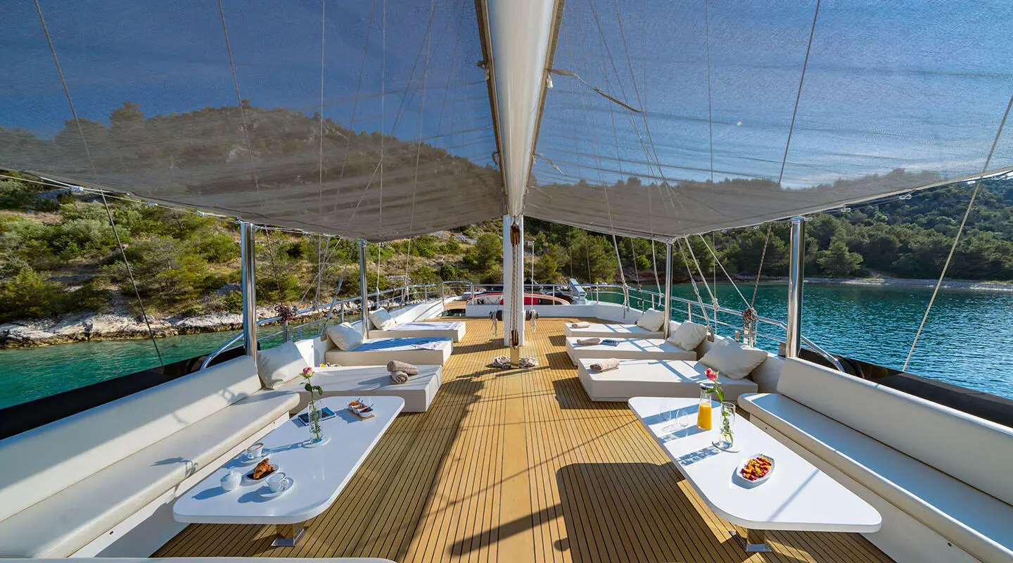 Navilux yacht sundeck with loungers and shaded seating area, calm water