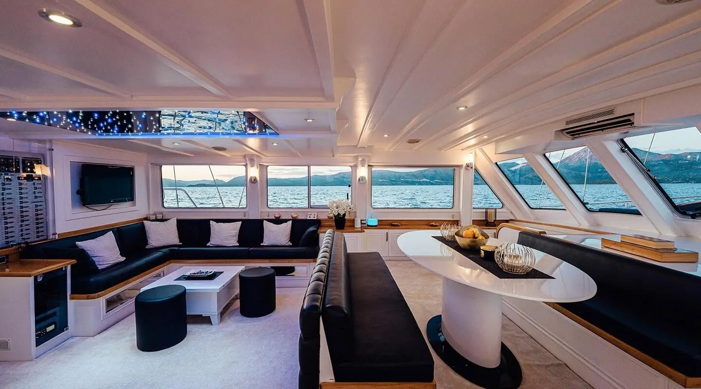 Maske yacht interior with black seating, white coffee table, large windows viewing the sea