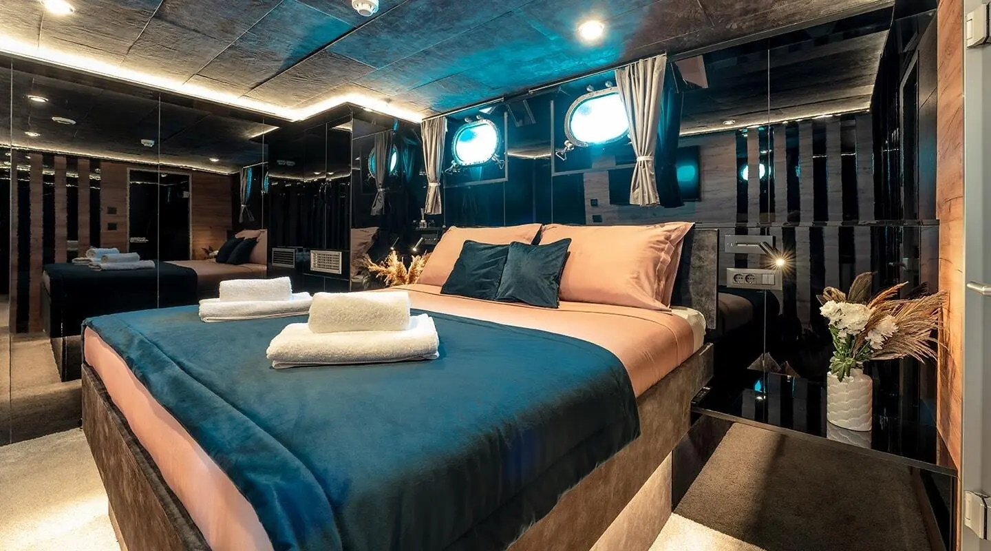 Bedroom with a large double bed and black mirrored walls